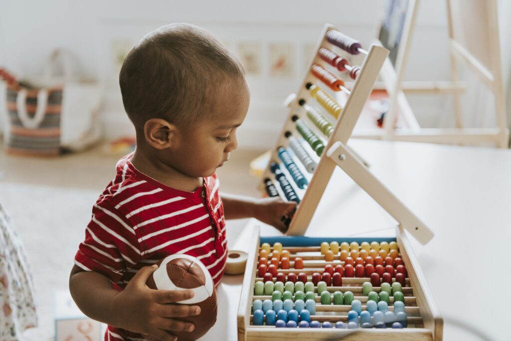 Get the child to think right, talk right, and act right. kid playing with a colorful wooden abacus